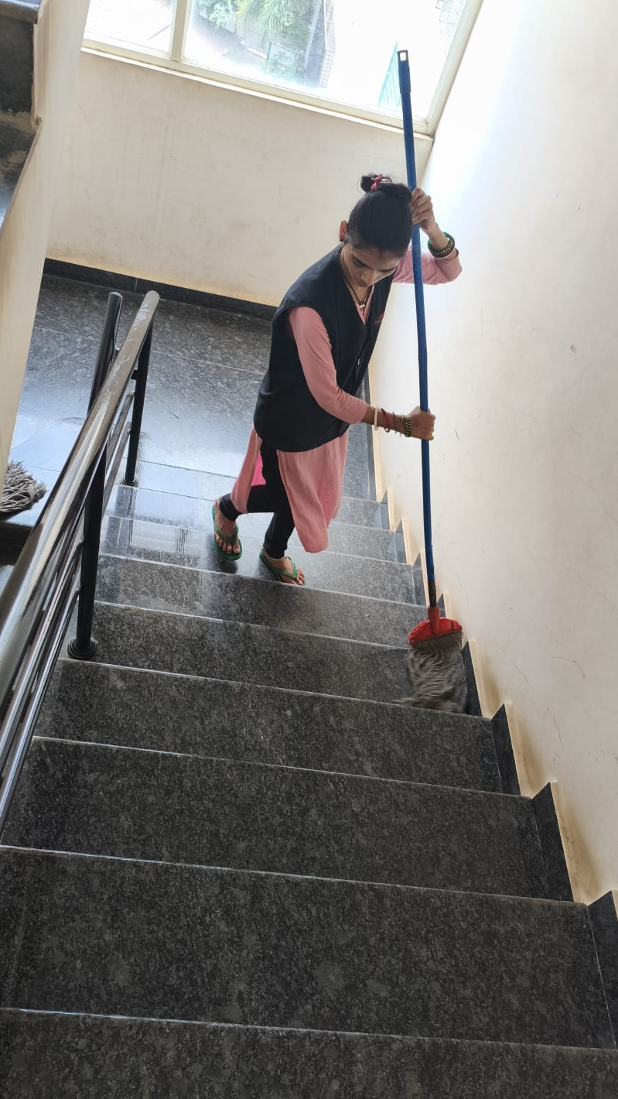 NV staff member mopping a stone staircase