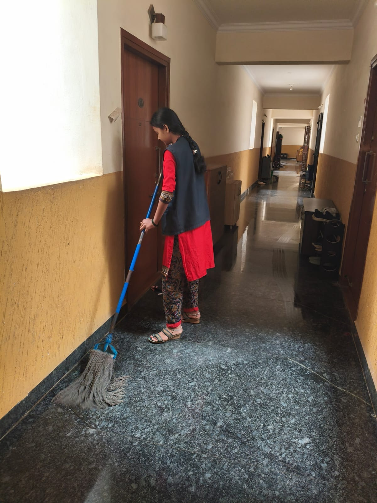 NV staff member mopping a polished indoor hallway